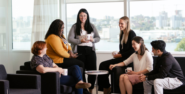 BOYNECLARKE colleagues talk together in a lounge area over coffee.