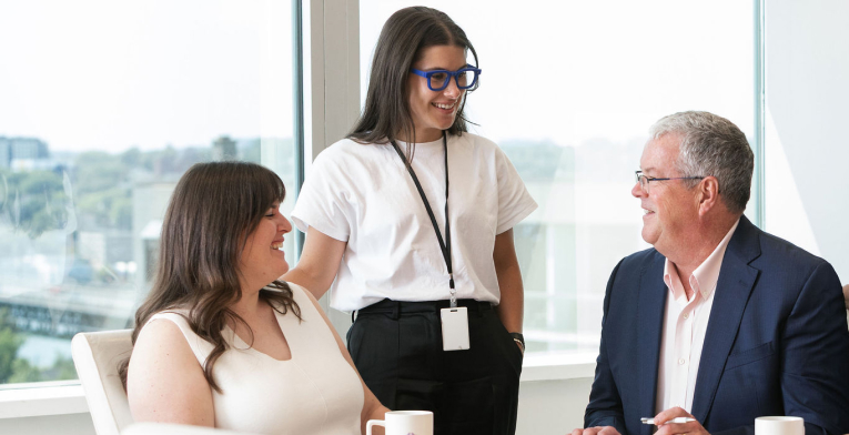 BOYNECLARKE colleagues talk together at a conference table.