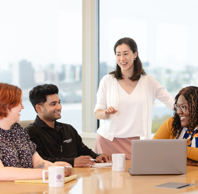 BOYNECLARKE colleagues talk together at a conference table during a meeting.